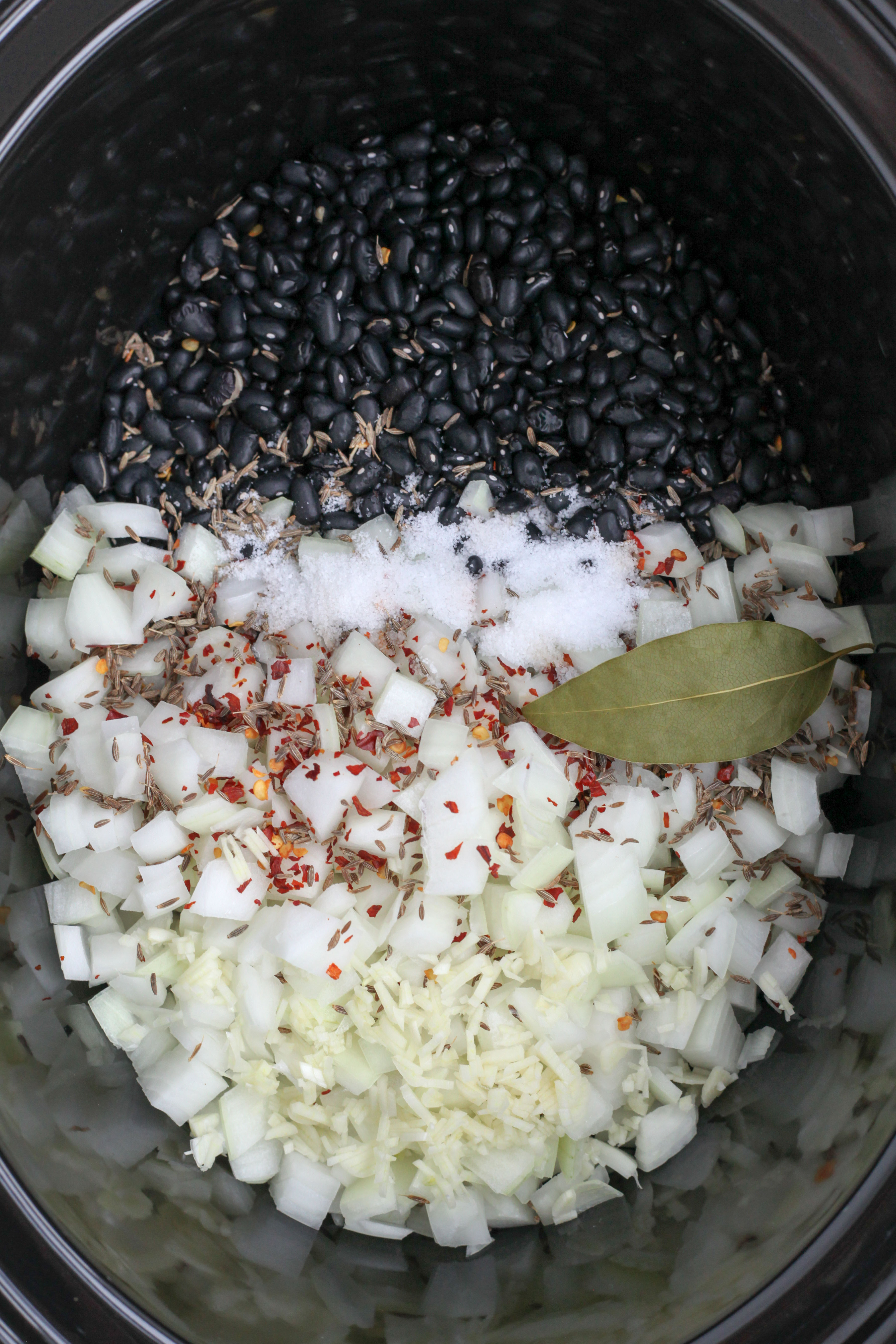Black beans and aromatics in a slow-cooker