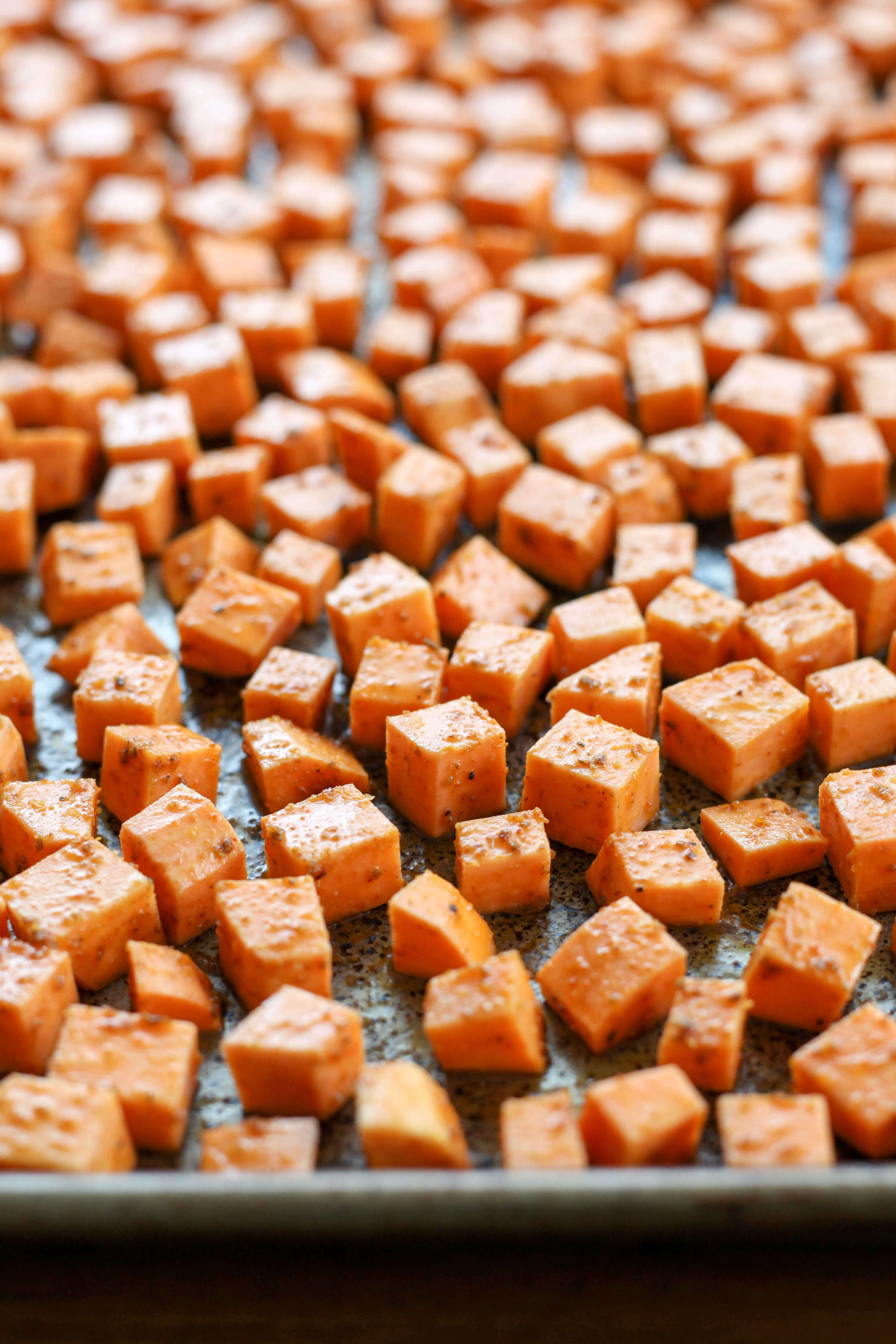 Diced spiced sweet potatoes, ready to be roasted