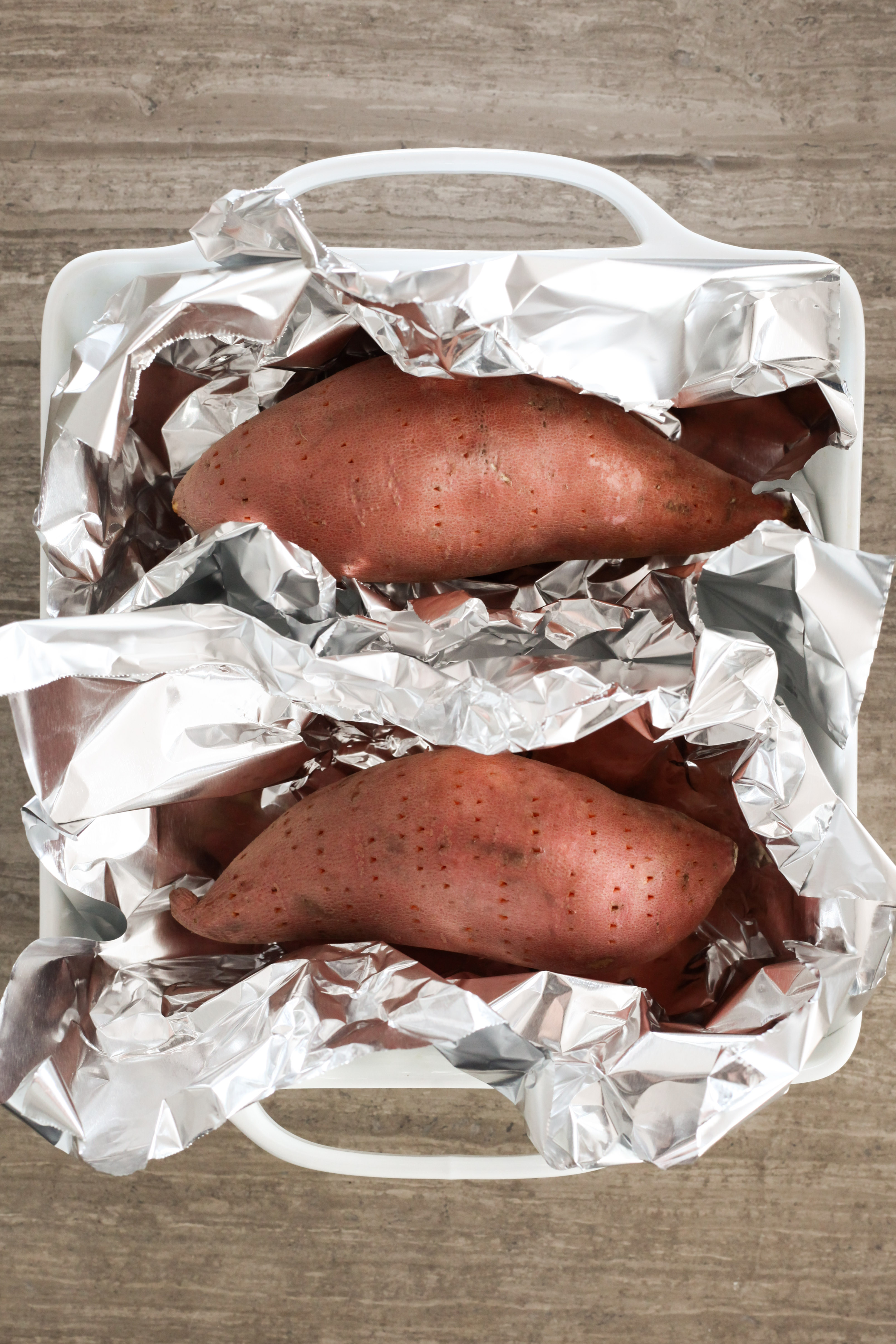 Pricked sweet potatoes ready to be roasted